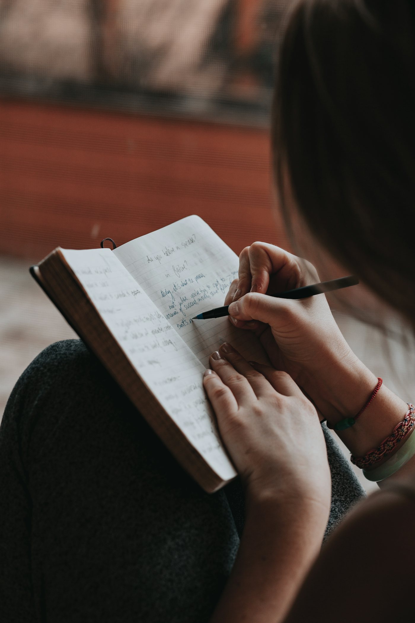 Cuaderno y manos escribiendo, el diario del coach