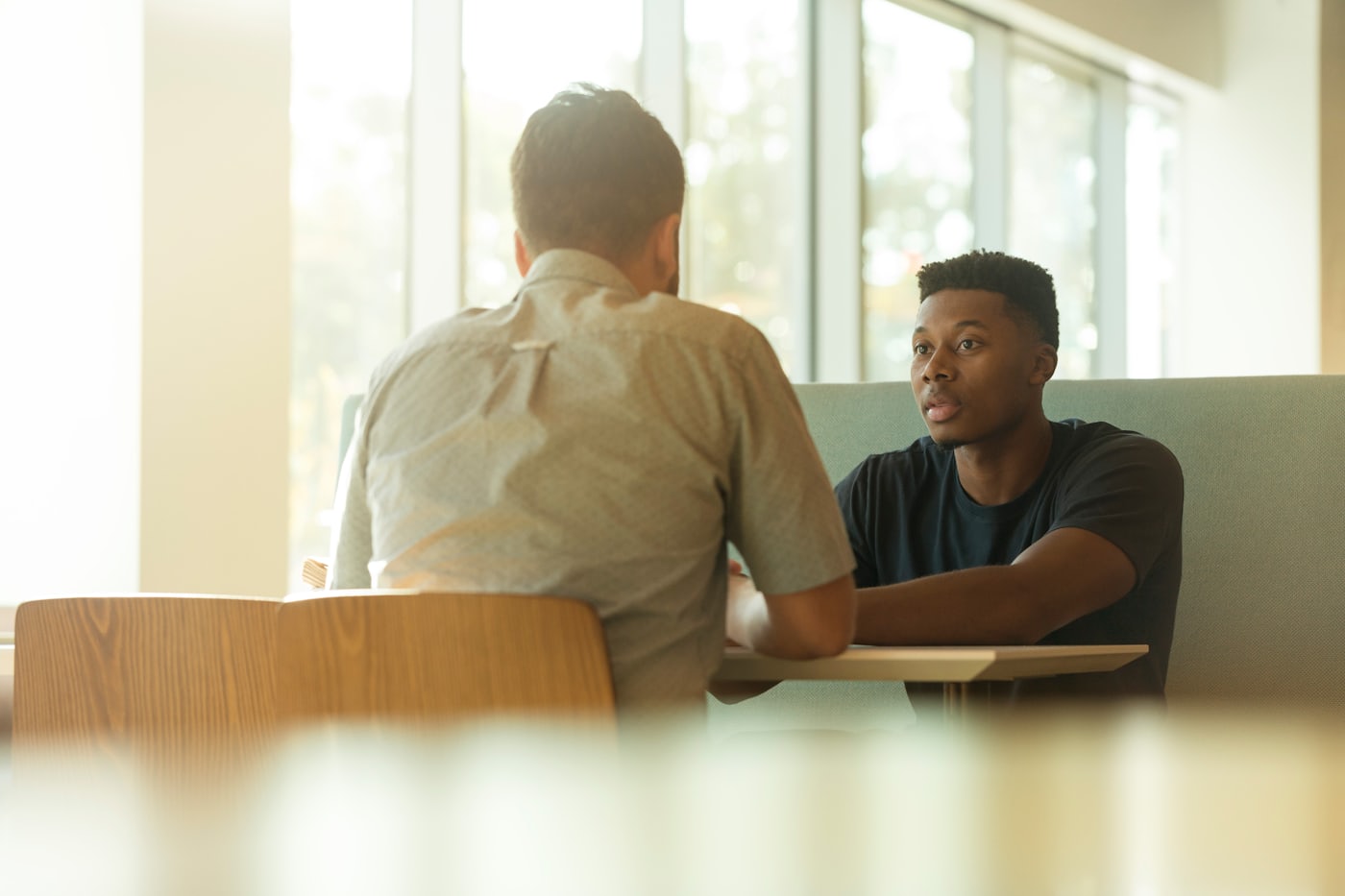 Dos personas en una conversación de coaching, con luz cálida